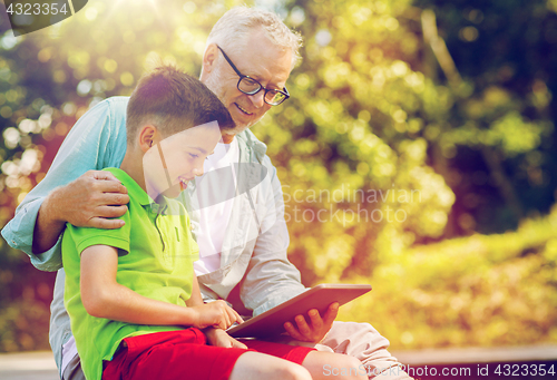 Image of happy grandfather and boy with tablet pc outdoors