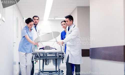 Image of medics with woman on hospital gurney at emergency