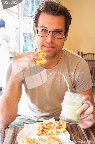 Image of Man eating traditional moroccan breakfast in coffee shop.