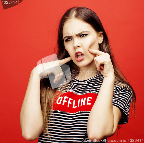 Image of young pretty emitonal posing teenage girl on bright red background, happy smiling lifestyle people concept 