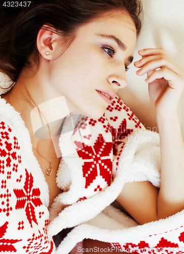 Image of young pretty brunette girl in Christmas ornament blanket getting