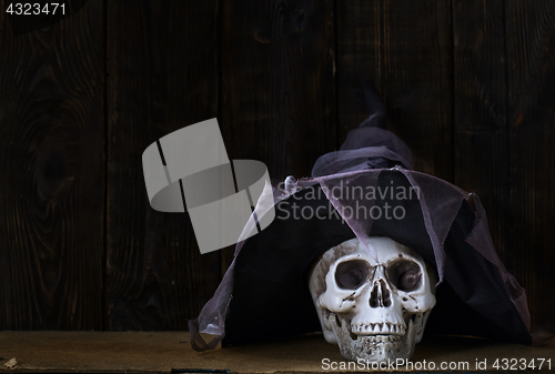 Image of Human skull with magician hat at the wooden wall