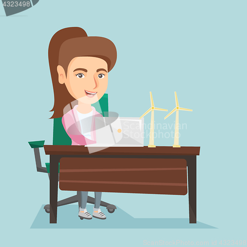 Image of Caucasian worker of wind farm working on a laptop.