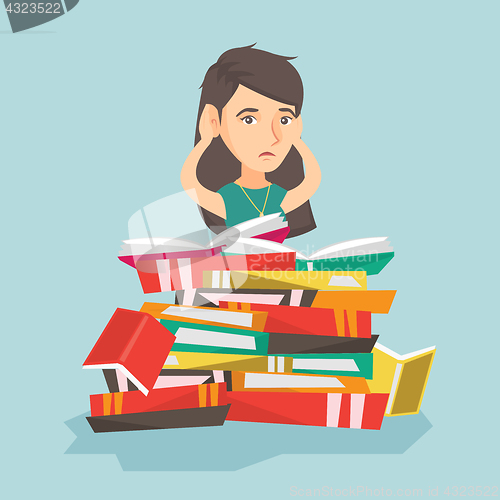 Image of Caucasian student sitting in a huge pile of books.