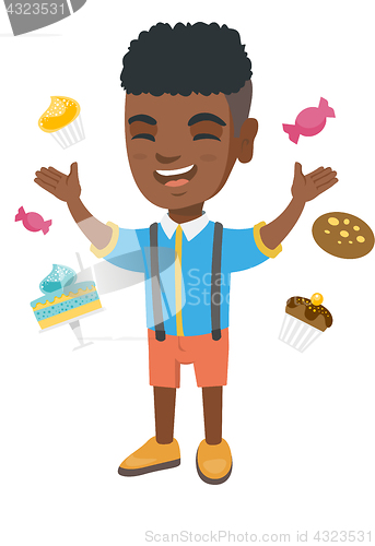 Image of Happy african boy standing among lots of sweets.