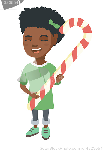 Image of African little girl holding christmas candy cane.