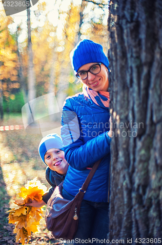 Image of Beauty woman and her son at autumn park