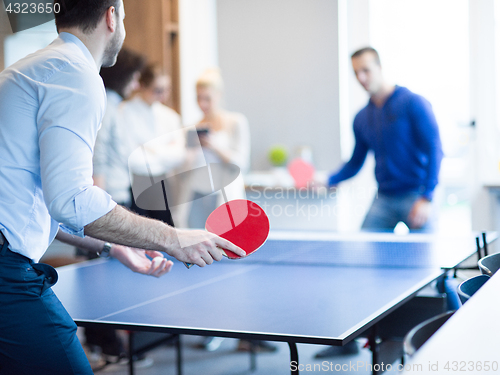 Image of startup business team playing ping pong tennis