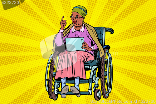 Image of elderly African woman disabled person in a wheelchair, gadget ta