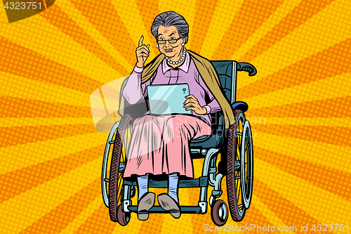 Image of elderly woman disabled person in a wheelchair, gadget tablet