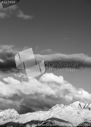 Image of Black and white view on snow winter mountains in clouds at sun e