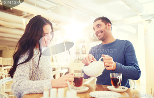 Image of happy couple drinking tea at cafe