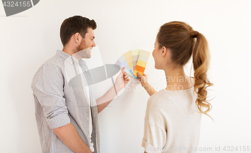 Image of happy couple with color samples at new home