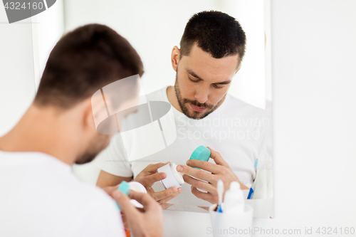 Image of young man with cream at bathroom