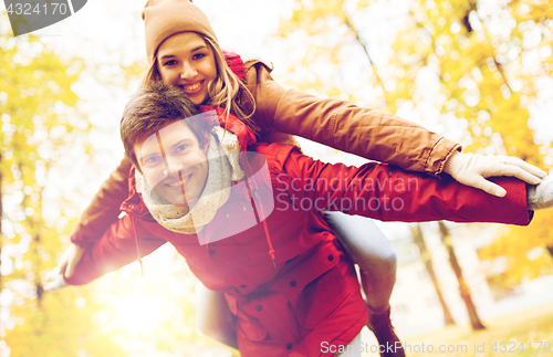 Image of happy young couple having fun in autumn park