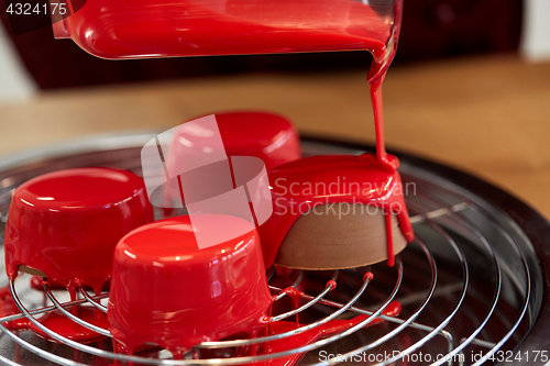 Image of jug pouring glaze to cakes at pastry shop