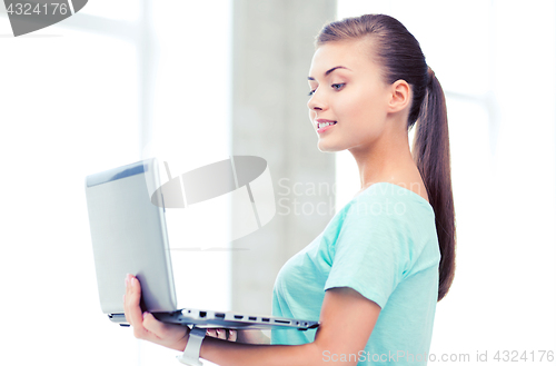 Image of smiling student girl with laptop at school