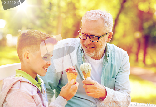 Image of old man and boy eating ice cream at summer park