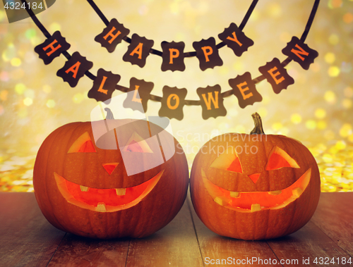 Image of carved pumpkins and happy halloween garland