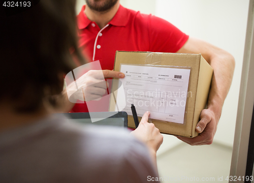 Image of delivery man with box, tablet pc and customer