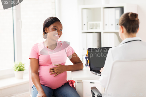 Image of doctor with laptop and pregnant woman at clinic