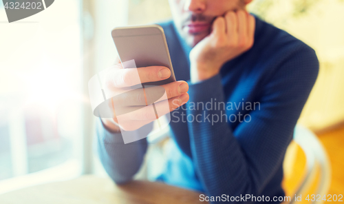 Image of close up of man with smartphones at cafe
