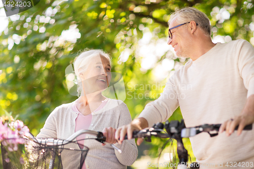 Image of happy senior couple with bicycles at summer park