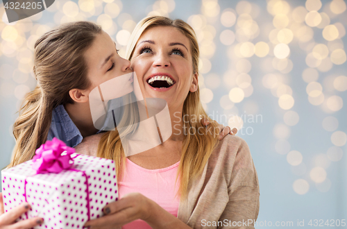 Image of girl giving birthday present to mother over lights