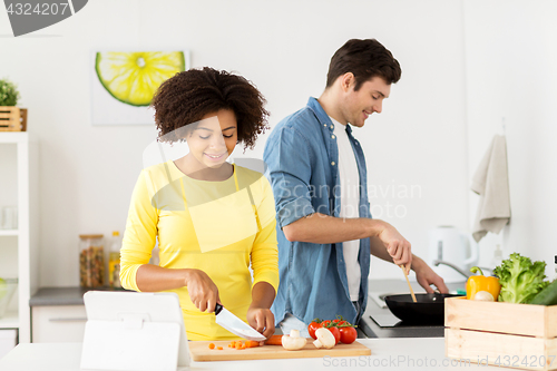 Image of happy couple cooking food at home kitchen