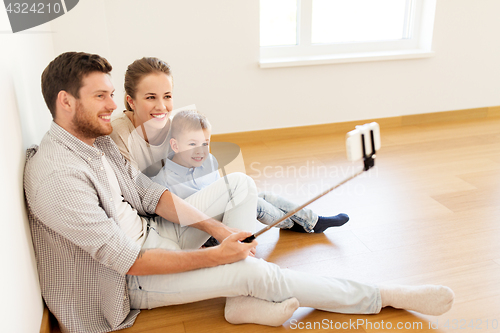 Image of family taking selfie by smartphone at new home