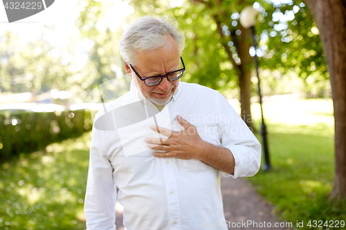 Image of senior man feeling sick at summer park