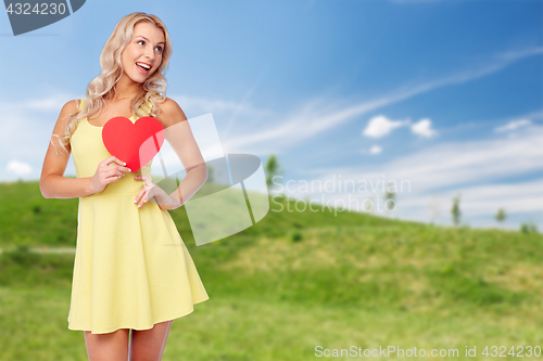 Image of happy young woman in summer dress with red heart