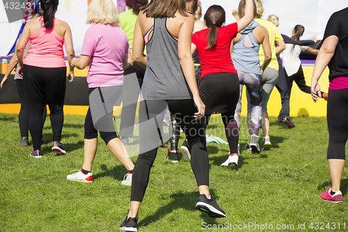 Image of Group of young girls exercising fitness with dancing in the city