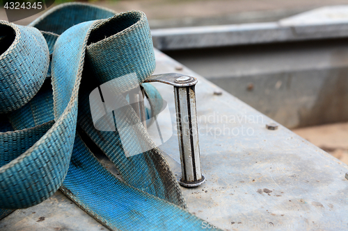 Image of Detail of metal buckle on a blue ratchet strap