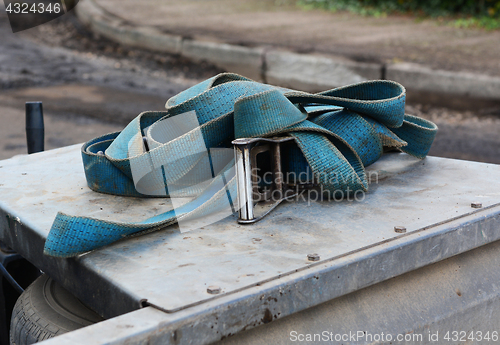 Image of Blue strap with a metal buckle on a trailer