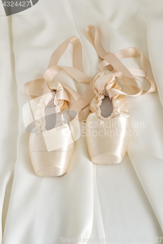 Image of Ballet pointe shoes on beige color fabric