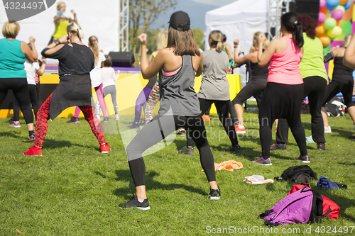 Image of Group of young girls exercising fitness with dancing in the city