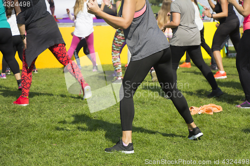 Image of Group of young girls exercising fitness with dancing in the city