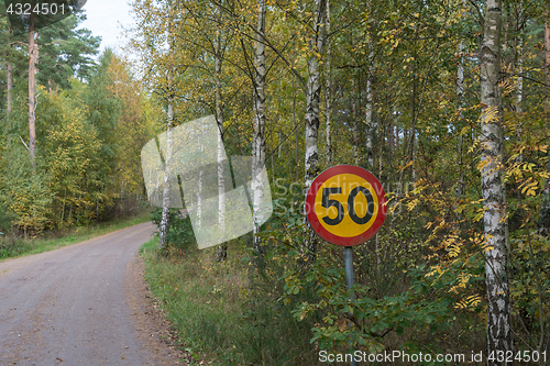 Image of Speed limit traffic sign by a gravel road
