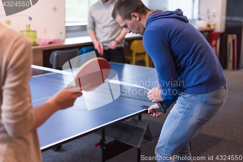 Image of startup business team playing ping pong tennis