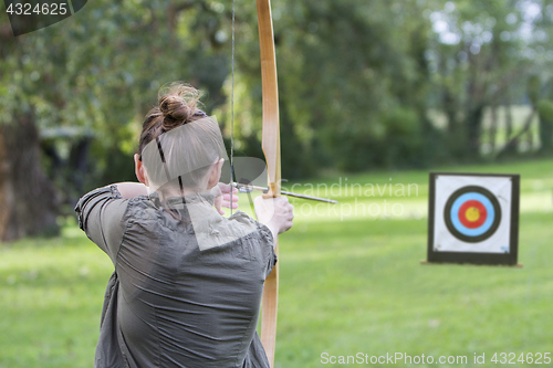 Image of Woman archer to use a bow and arrow and shoot at a target