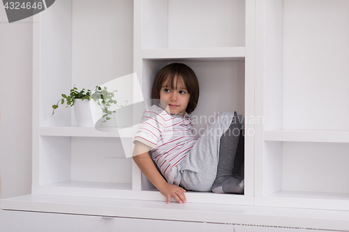 Image of young boy posing on a shelf