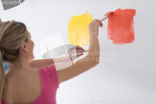 Image of couple painting interior wall