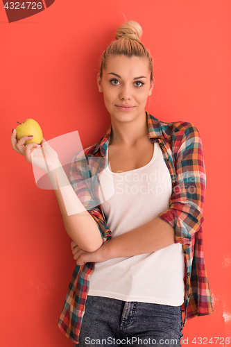 Image of woman over color background plays with apple