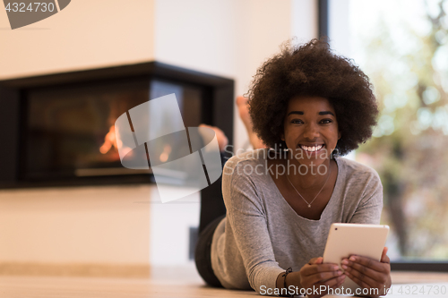 Image of black women using tablet computer on the floor