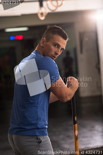 Image of man workout with hammer and tractor tire