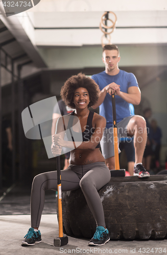 Image of multiethnic couple after workout with hammer