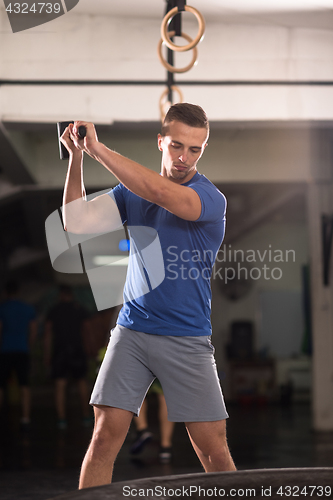 Image of man workout with hammer and tractor tire