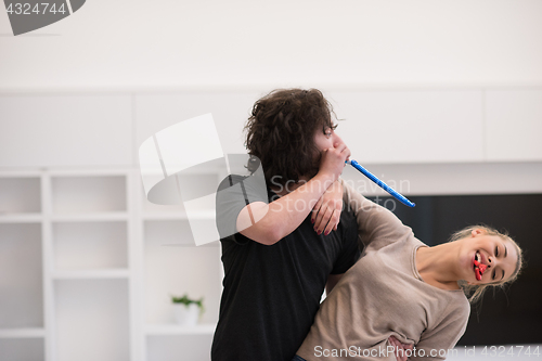 Image of couple in party hats blowing in whistle