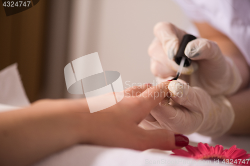 Image of Woman hands receiving a manicure